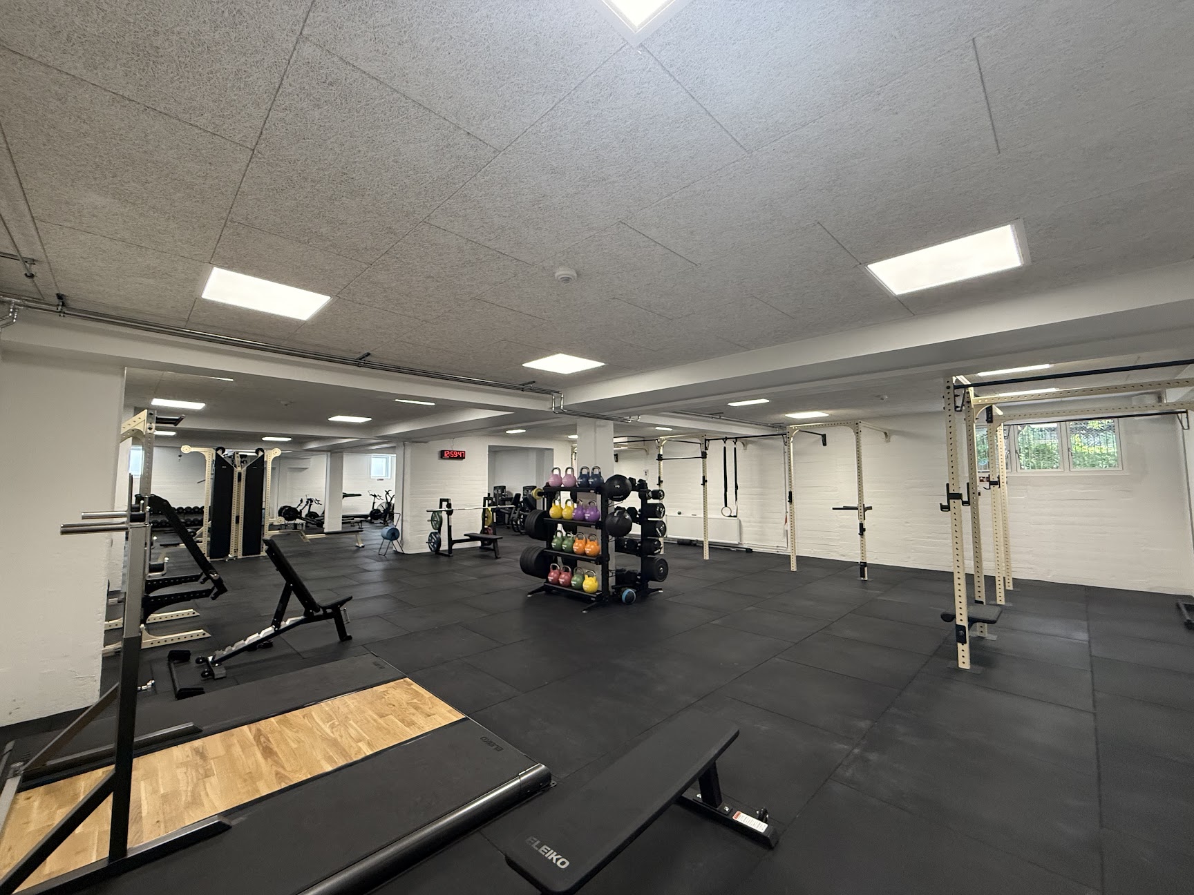 Træningsgulvet i Meiers Gym i Odense med styrketræningsudstyr, sorte gulve og lyse racks